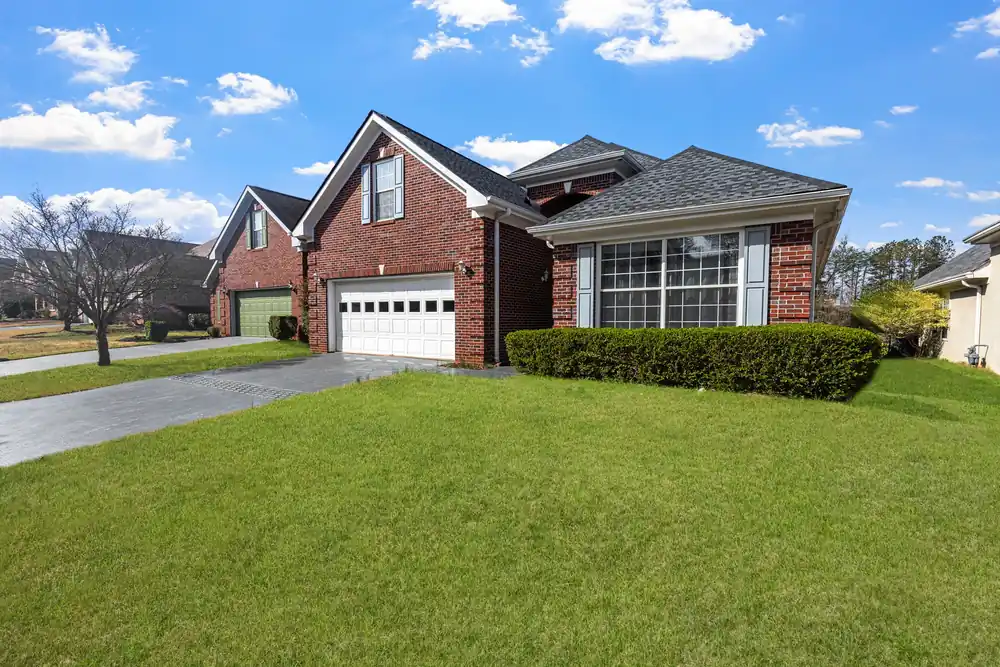 Brick home with an asphalt shingle roof under a clear Tennessee sky