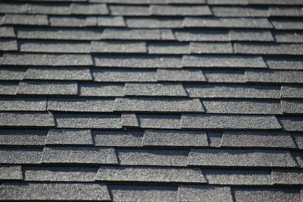 Close view of overlapping asphalt shingles showing their protective granule surface